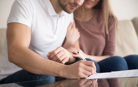 stock-photo-close-up-of-couple-signing-documents-young-man-putting-signature-on-document-his-wife-sitting-622355582_1.jpg