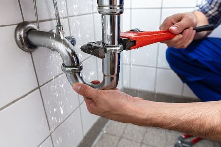 stock-photo-male-plumber-s-hand-repairing-sink-pipe-leakage-with-adjustable-wrench-1149190532_1.jpg